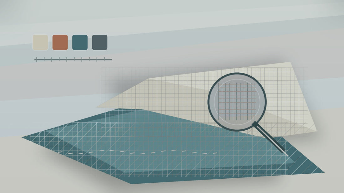 Layered bedding fabric samples with a magnifying glass highlighting weave quality.